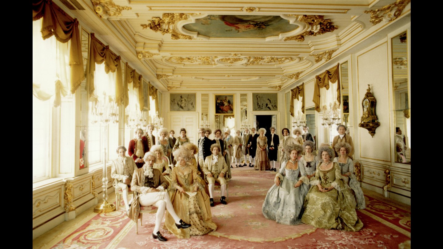 Filmstill aus BELLE VAN ZUYLEN: Eine Gruppe fein gekleideter Figuren befindet sich in einem prunkvollen Raum.