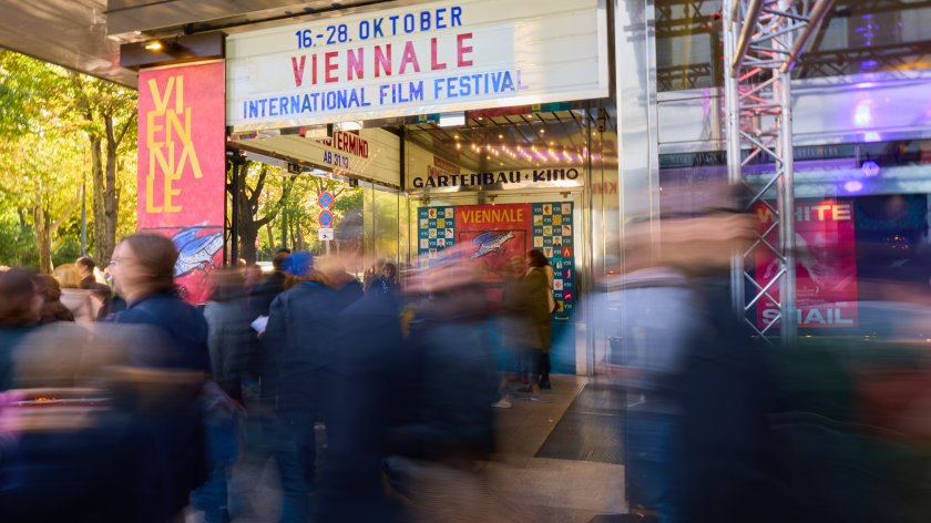 Menschenmenge vor dem Eingang des Gartenbau-Kinos mit Leuchtreklame für die Viennale International Film Festival vom 16. bis 28. Oktober